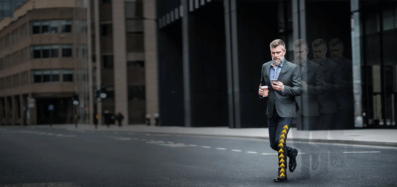 Man in a suit walking on a city street with a building in the background