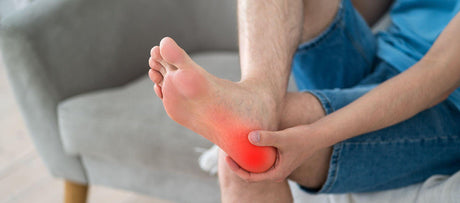 Man holding heel with pain radiating from heel and plantar fascia.