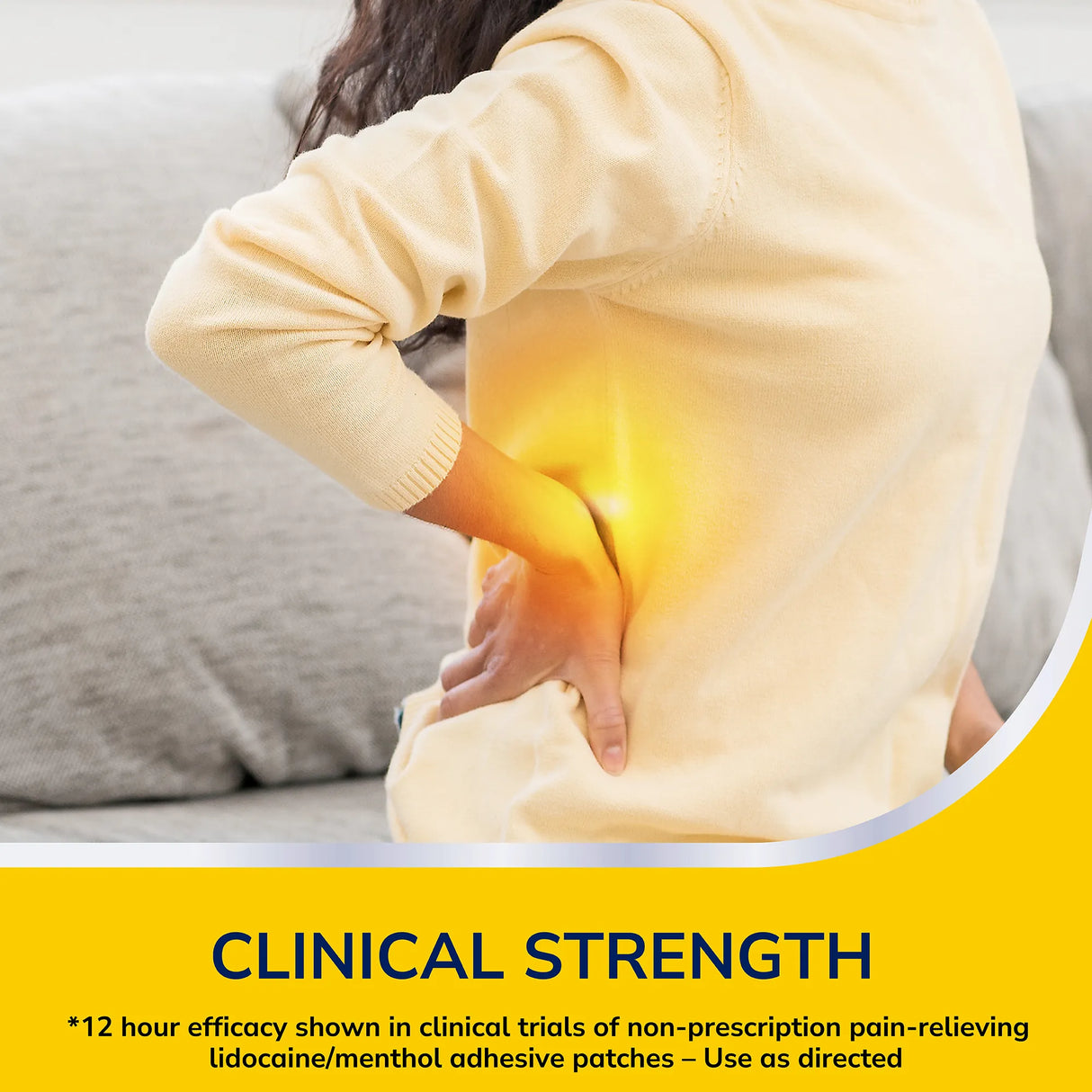 Person holding their lower back with a glowing yellow area indicating pain for Dr Scholls Clinical Strength patches