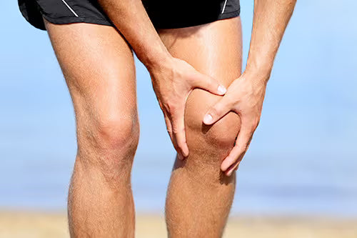 Runner holding knee with both hands