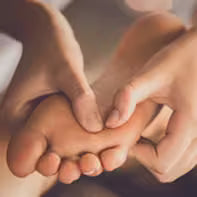 Close-up of a child's foot being held by an adult's hands